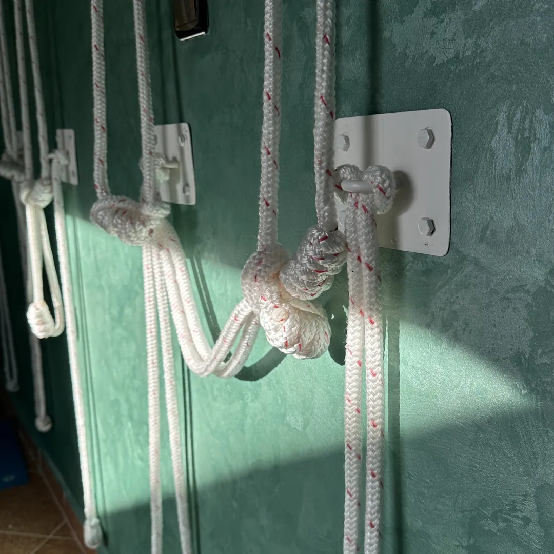 Détail des cordes Iyengar au mur – nœuds et platines.